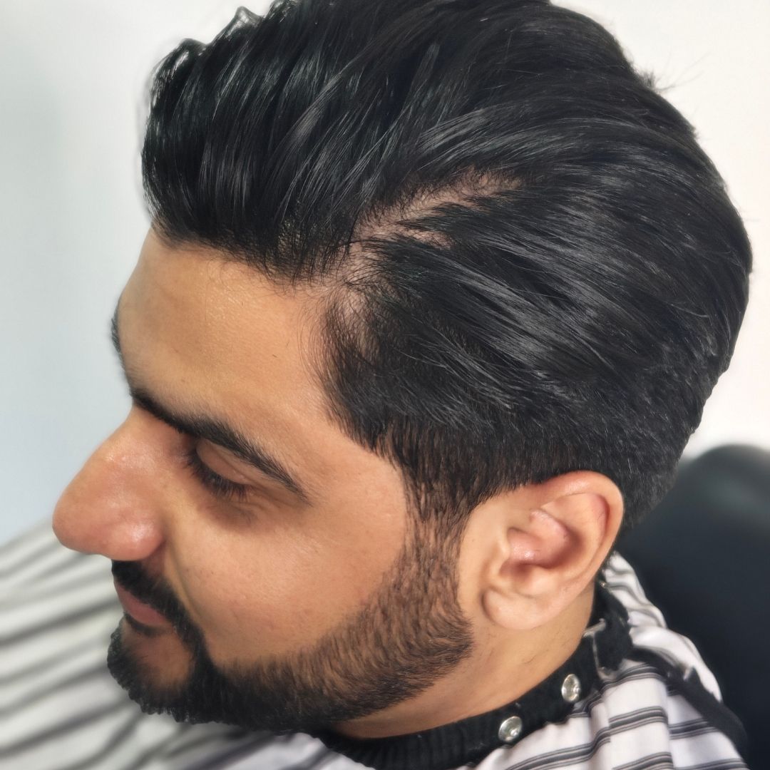 Men's precision haircut with styled dark hair and clean fade side profile